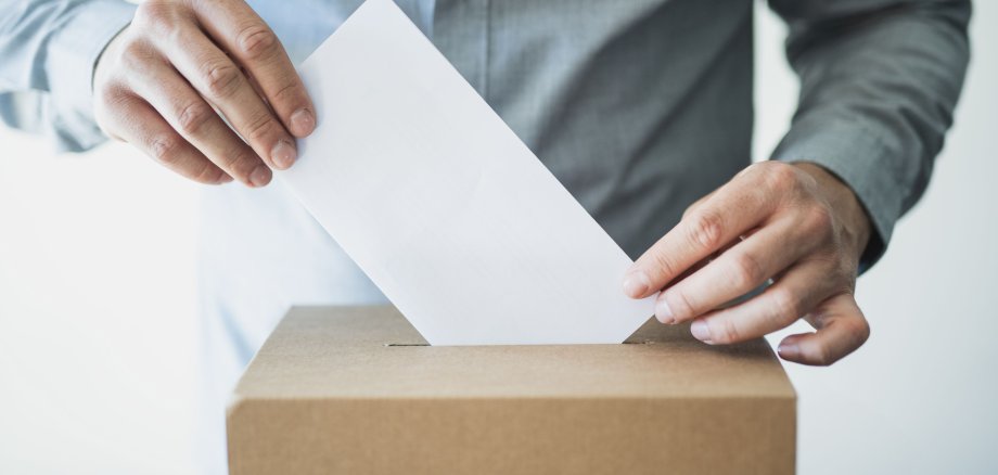 Hand of unrecognisable person Voting in ballot box in election day.